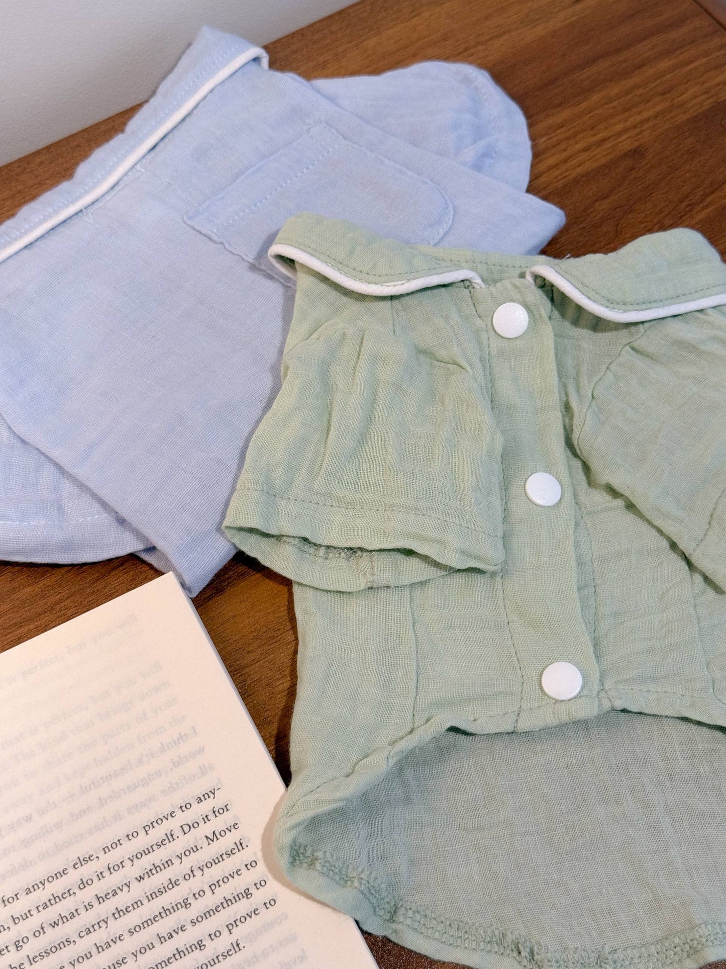 sage green pet pajamas next to aa dusty blue folded pet pajamas