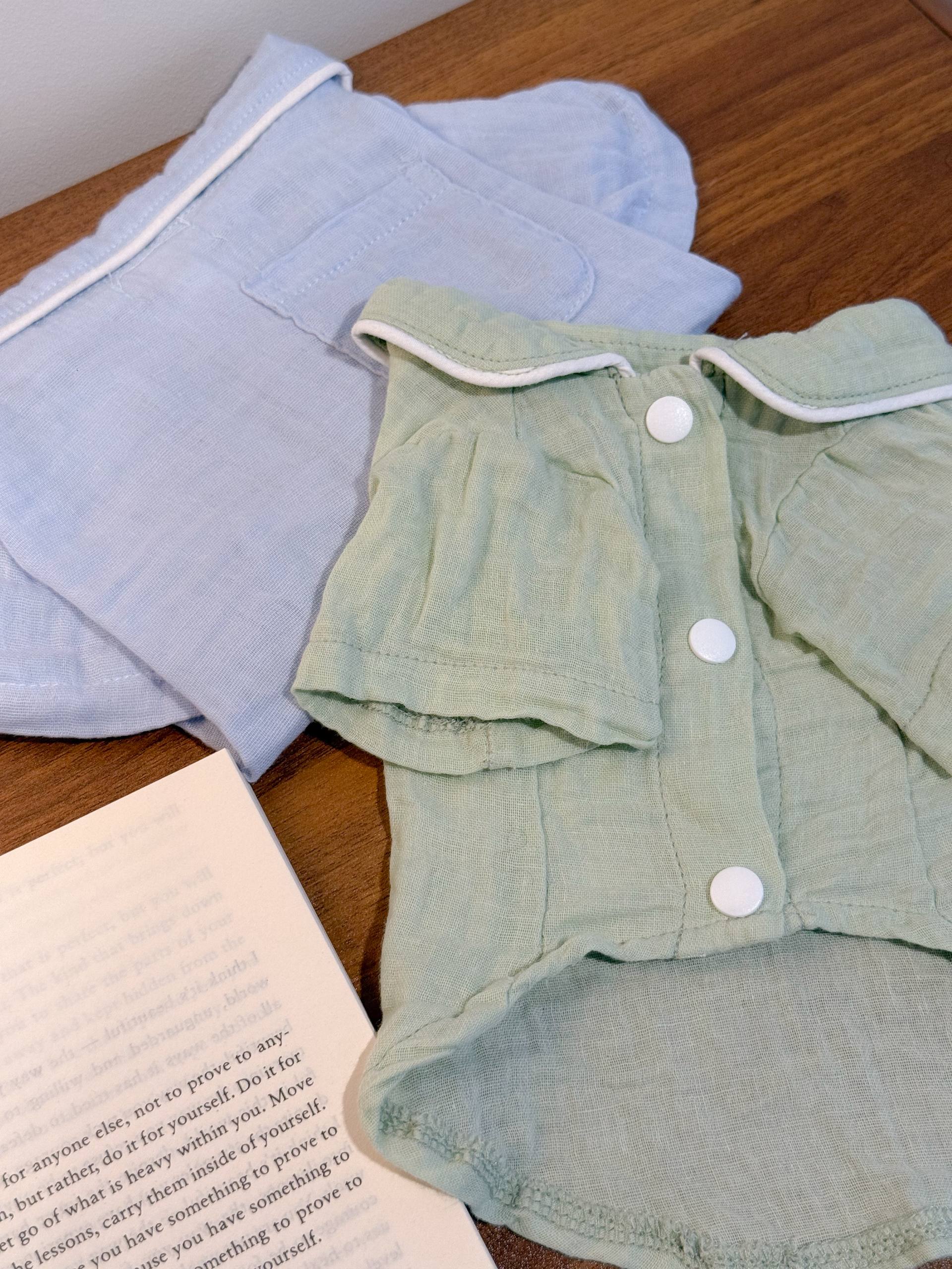 sage green pet pajamas next to aa dusty blue folded pet pajamas